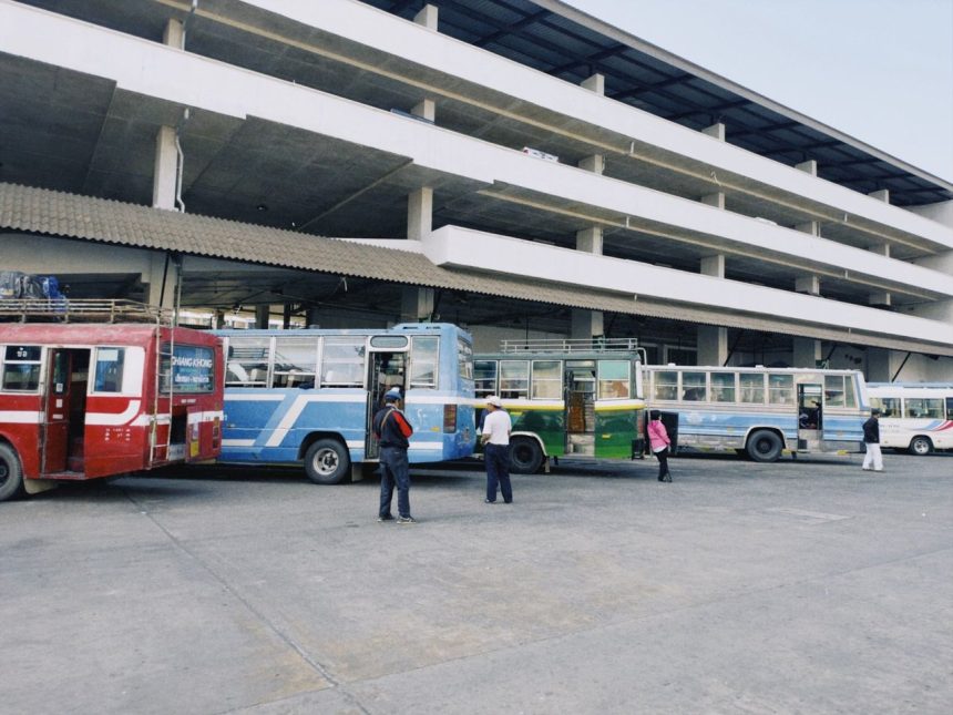 Ônibus coloridos estacionados em uma estação de transporte público urbano.